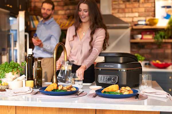 A woman cooking a nice meal in their kitchen with the Russell Hobbs Air & Grill Multicooker. 